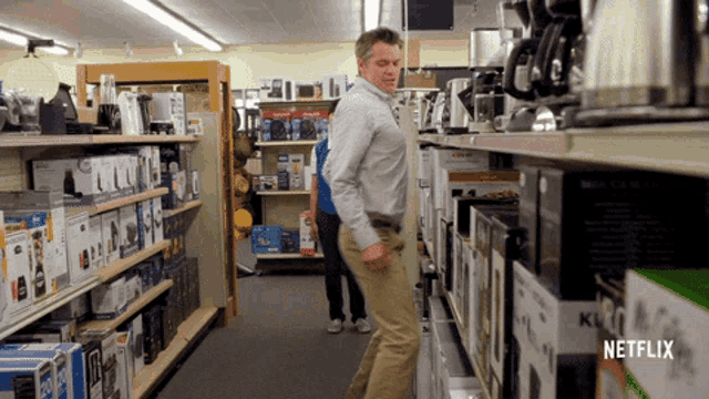 a man standing in a store with a netflix logo on the bottom right