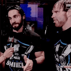 two men wearing shield shirts are giving the middle finger