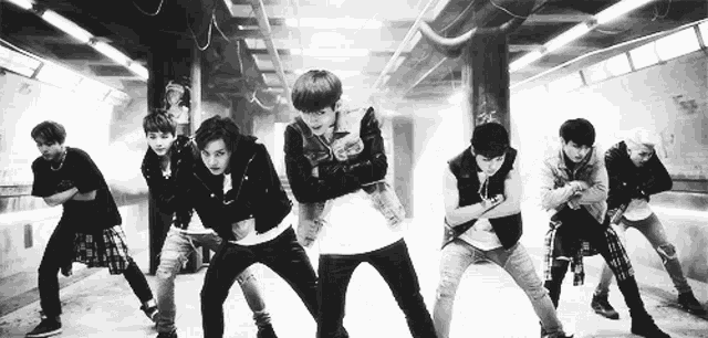 a black and white photo of a group of young men dancing together