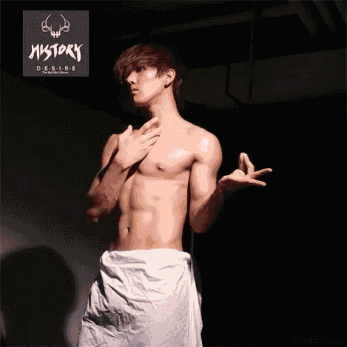 a shirtless man stands in front of a sign that says history desire