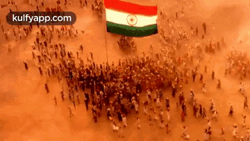 an aerial view of a large group of people holding a flag .