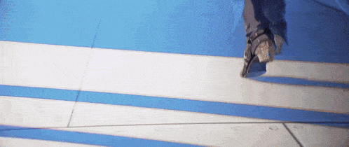a person is rollerblading on a blue and white striped floor