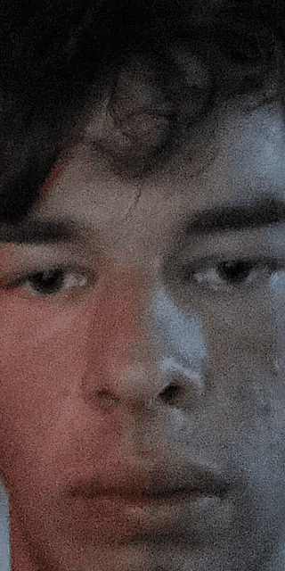 a close up of a man 's face with a red spot on the left side
