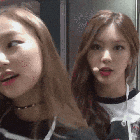 two girls are standing next to each other and one has a microphone in her hand