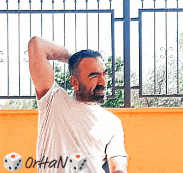 a man with a beard wears a white shirt with the word ortan on the back