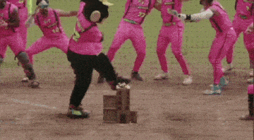 a monkey mascot in a pink shirt is dancing on a baseball field .