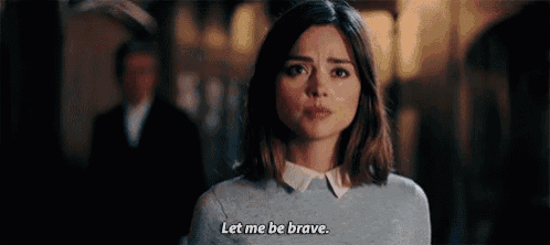 a woman is standing in front of a man and saying `` let me be brave . ''