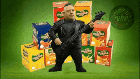 a man is playing a guitar in front of boxes of juice