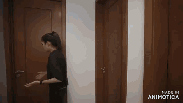 a woman opens a door with the words made in animatica on the bottom right
