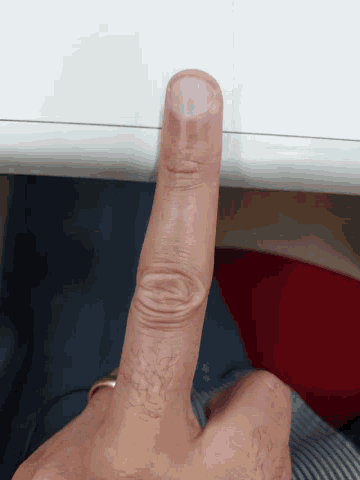 a close up of a person 's finger pointing to a white surface