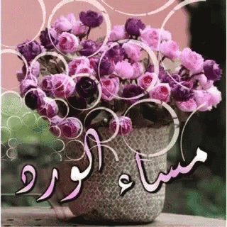 a vase filled with pink and purple flowers with arabic writing on it .