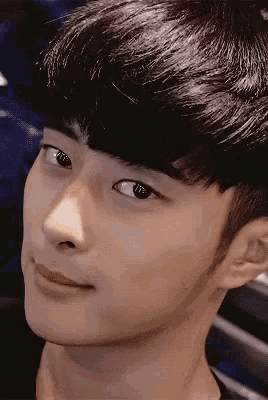 a close up of a young man 's face with a slight smile on his face