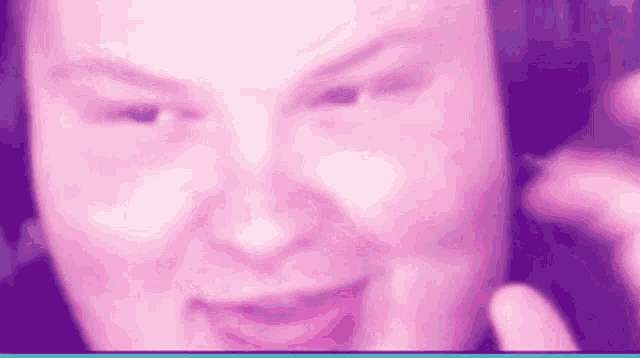 a close up of a person 's face with a pink background and headphones on .