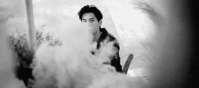a man is standing in a cloud of smoke .