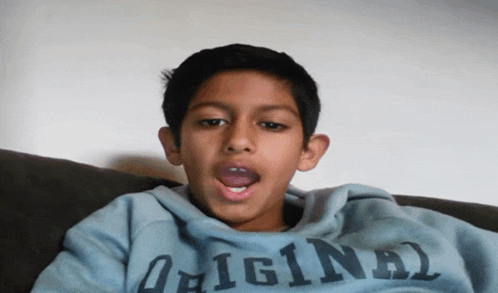 a young boy is wearing a blue sweatshirt that says original