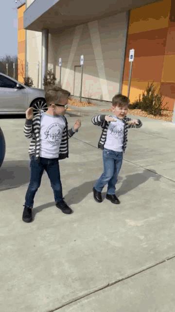 two young boys wearing shirts that say " hope " are dancing on a sidewalk