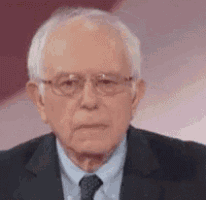 sanders is wearing glasses and a suit and tie .