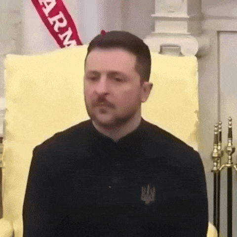 a man with a beard and mustache is standing in front of a yellow couch .