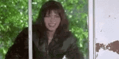 a woman is smiling while looking out a window .