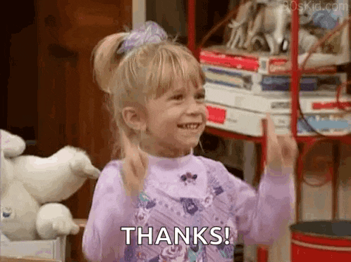 a little girl in a purple shirt is giving a thumbs up and saying thanks .