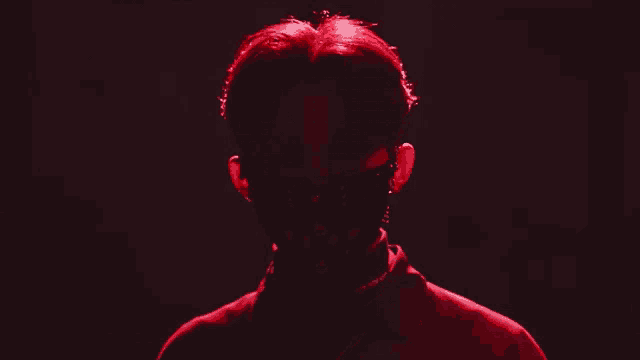 a man with red hair wearing a black mask with studs on it