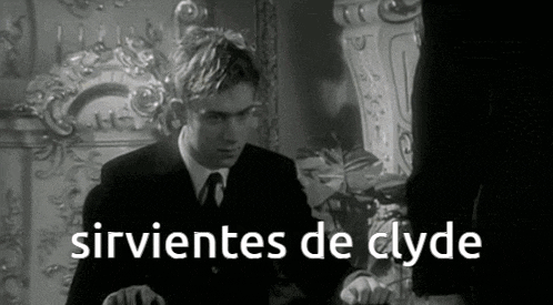 a black and white photo of a man in a suit and tie with the words sirvientes de clyde above him