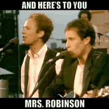 two men are singing into microphones and playing a guitar on stage .