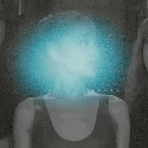 a woman with a blue light coming out of her head is in a black and white photo .