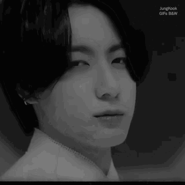 a close up of jungkook 's face in a black and white photo .