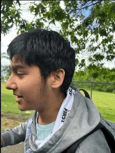a young man wearing a grey hoodie with the word first on the hood