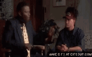two men are sitting on a couch and one of them is wearing a visor that says ' ss ' on it