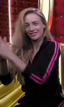 a woman wearing a black jacket with pink stripes on the sleeves is smiling