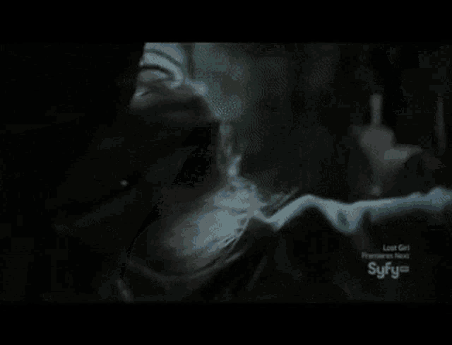 a syfy logo can be seen in the corner of a dark room