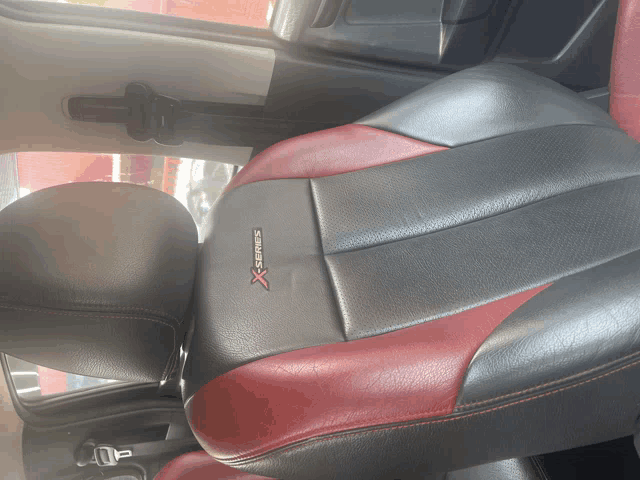 a black and red seat in a car with the word x series on it