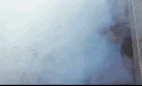 a blue background with a lot of smoke coming out of it .