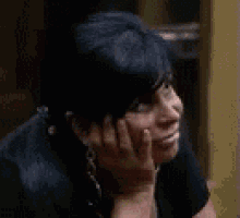 a woman with her hands on her face is smiling .