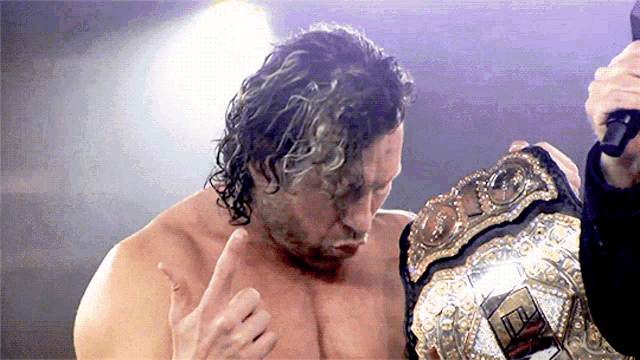 a wrestler is holding a world heavyweight wrestling championship