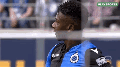 a soccer player wearing a blue and black jersey with the word play sports on the bottom right