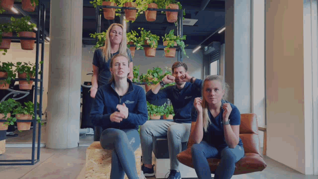 a group of people are posing for a picture and one of them is wearing a shirt that says ' asics '