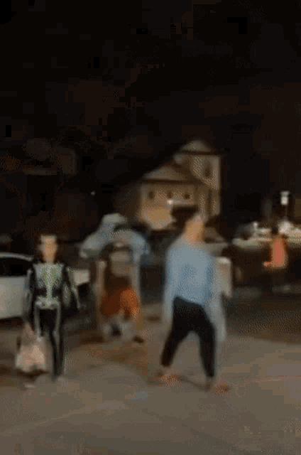 a group of people dressed in costumes are walking down a street at night