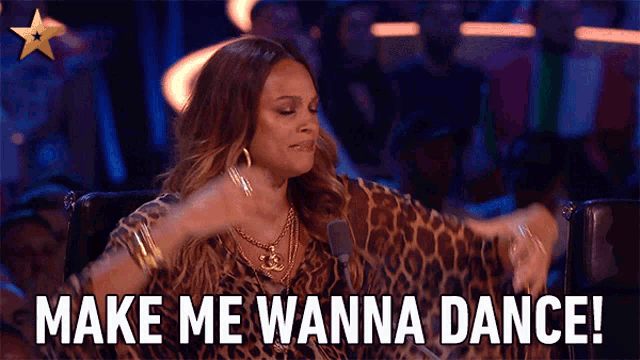 a woman in a leopard print shirt says make me wanna dance in front of a crowd