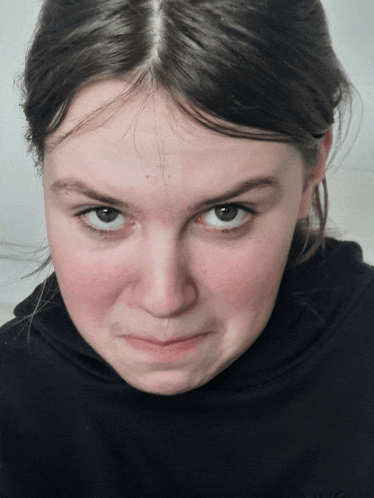 a young woman making a funny face wearing a black nyc shirt