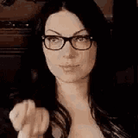 a woman wearing glasses is making a rude gesture with her middle finger .