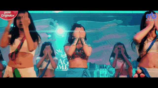 a group of women are dancing in front of a sign that says ' originals ' on it