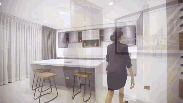 a woman in a business suit is walking through a kitchen