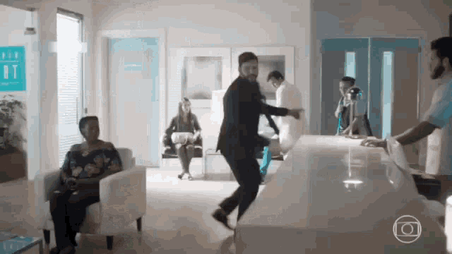 a man in a suit is dancing in a hospital waiting room