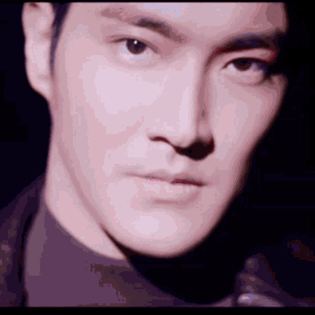 a close up of a man 's face with a black background