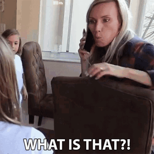a woman is sitting on a couch talking on a cell phone with the words what is that written below her