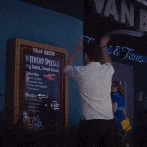 a man standing in front of a van beek sign