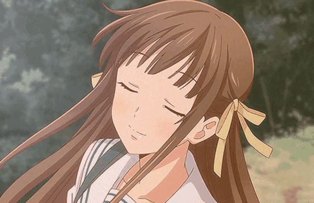 a close up of a girl with her eyes closed and a yellow bow on her hair